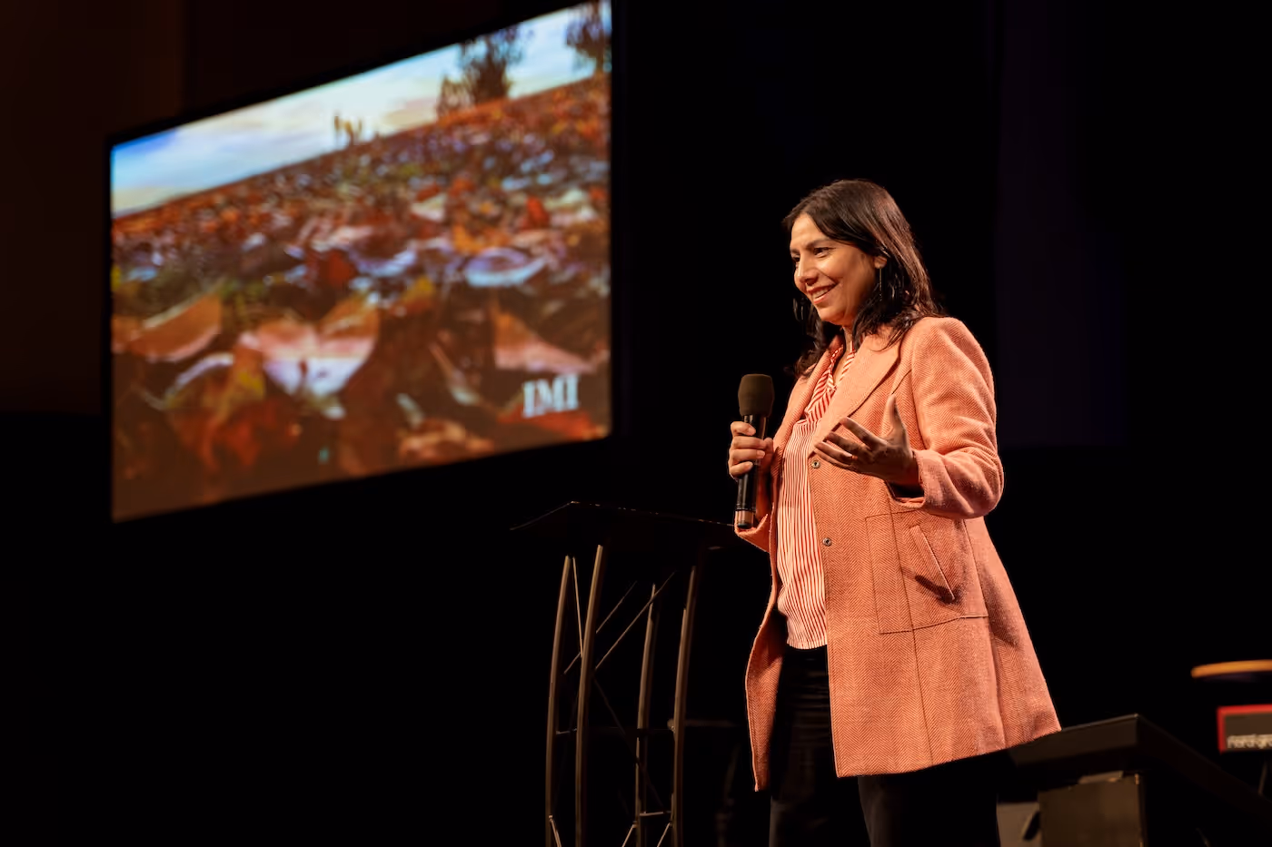Bildet viser Gulnaz Naushad på en scene med mikrofon i hånda