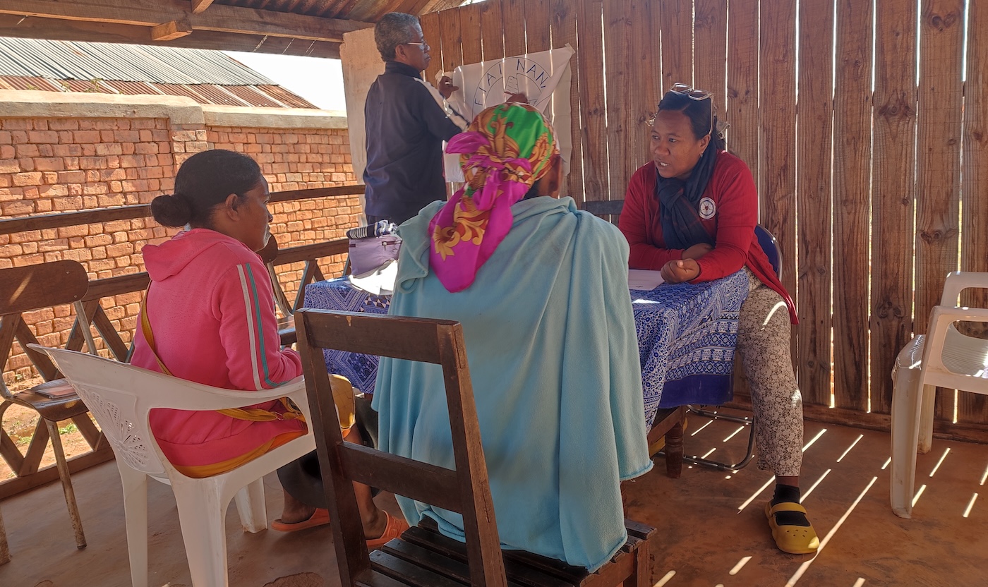 Bildet viser fire personer som sitter rundt et bord i skyggen