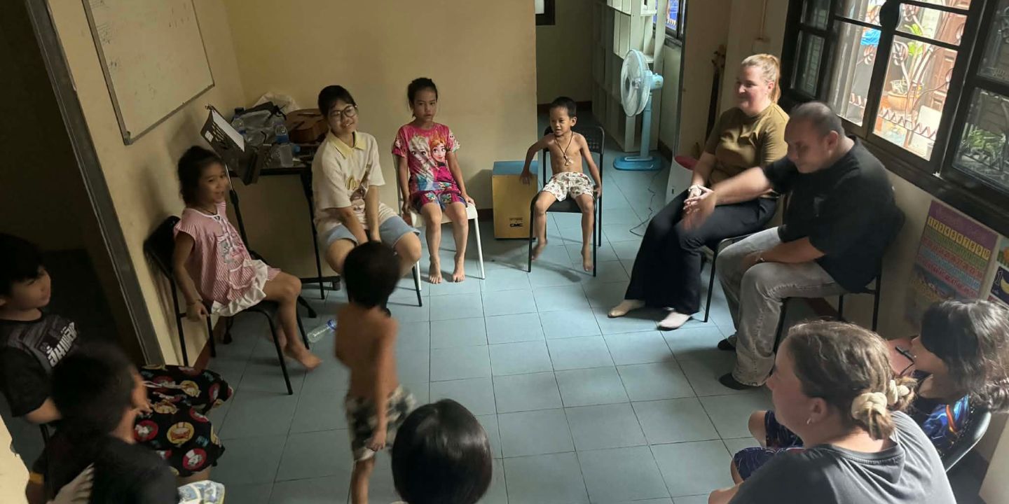 Bildet viser barn som sitter i en ring og leker leken «fruktsalat»