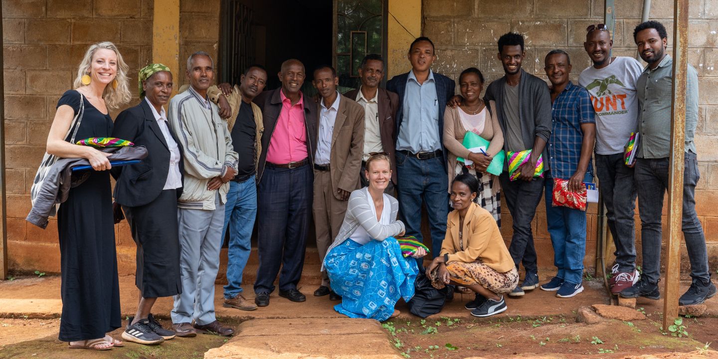 Bildet viser Marit Breen sammen med en gruppe mennesker utenfor et bygg