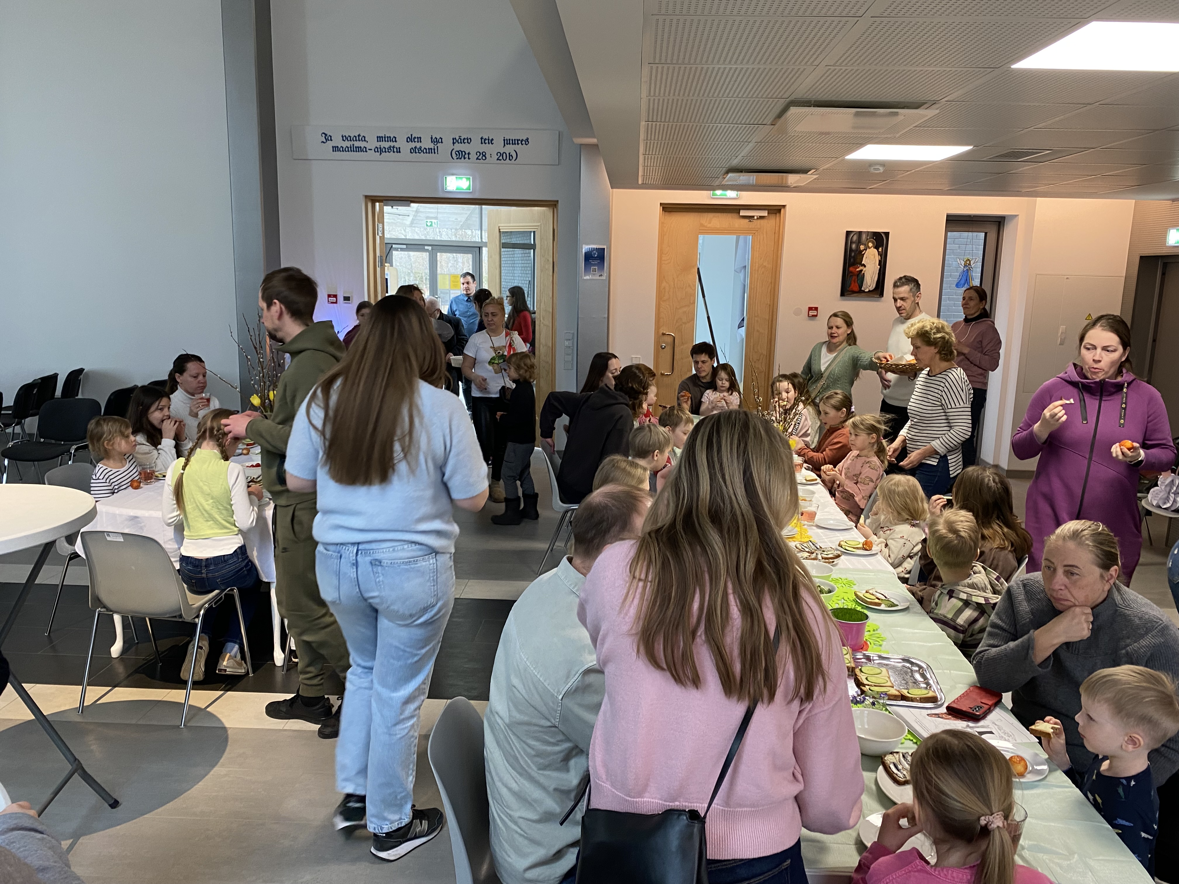 Bildet viser mange mennesker rundt bordene i Saku kirke