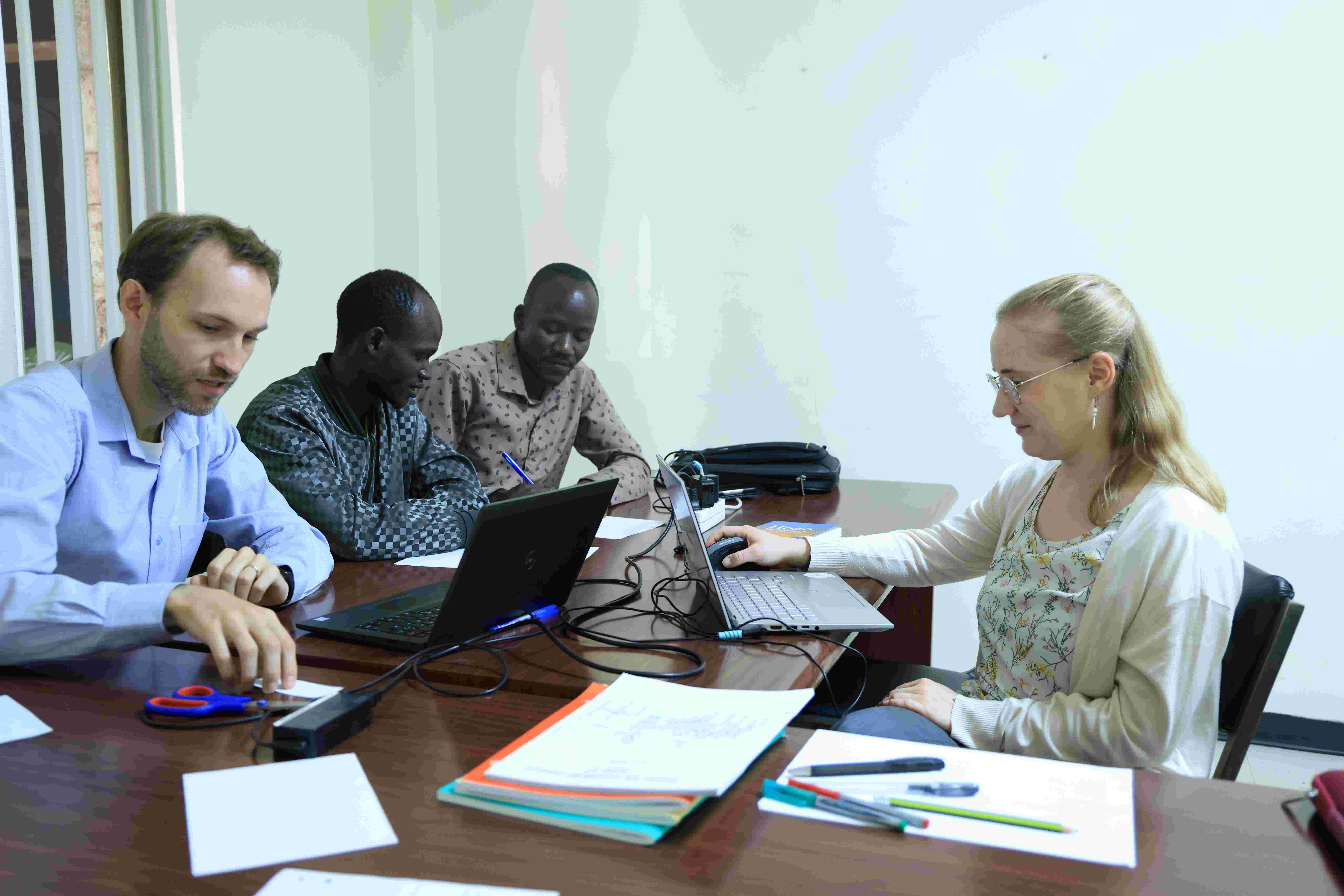 Bildet viser fire personer som jobber sammen rundt et bord