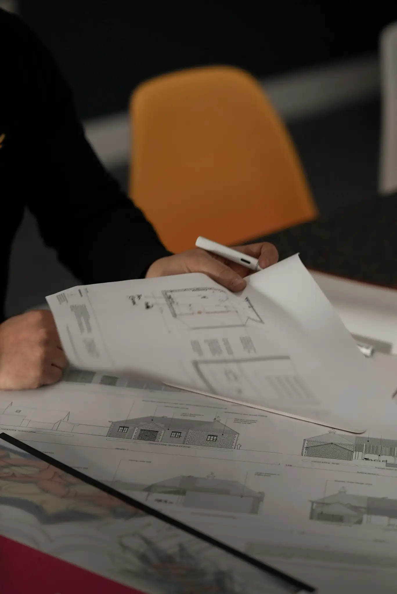 A set of architects plans laid on a table.