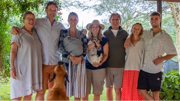 Relaxed family enjoys outdoor quality time with their happy baby and pets in nature.
