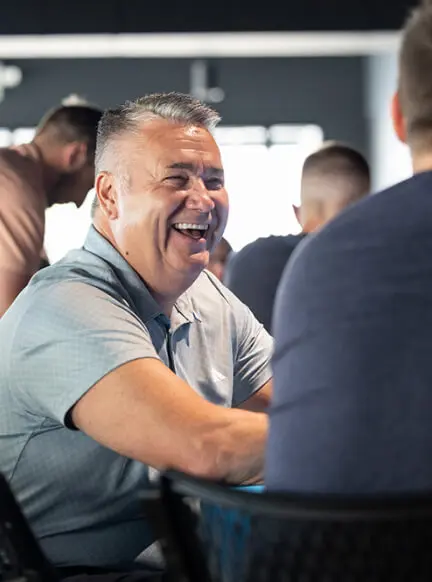 Man laughing while talking in a casual team setting.