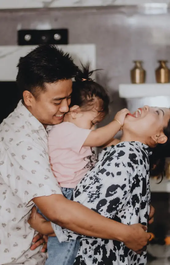 Man holding a baby and smiling with a woman.