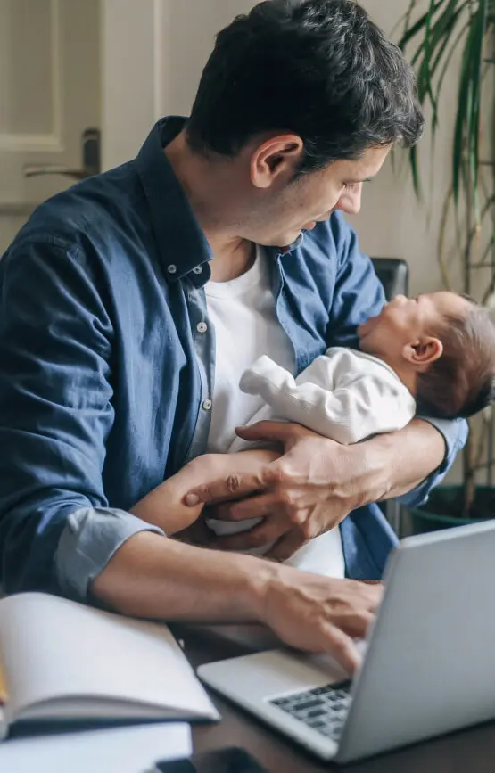 Man working from home holding a baby.