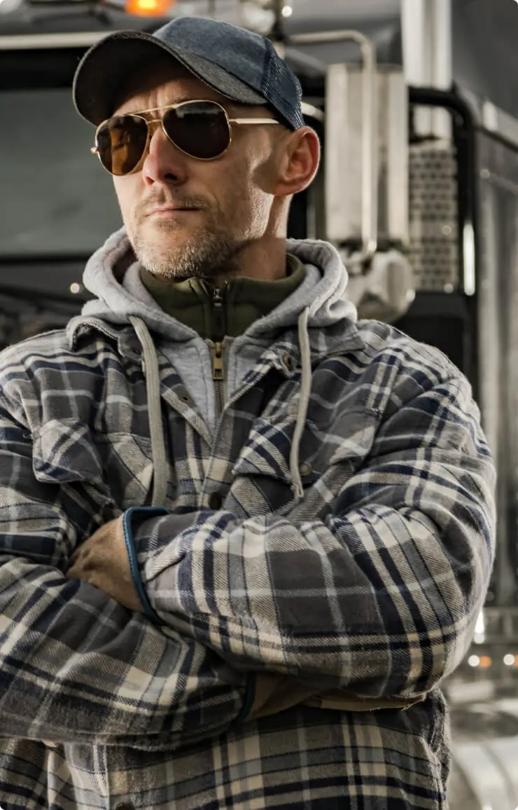 Man in sunglasses and jacket standing confidently.