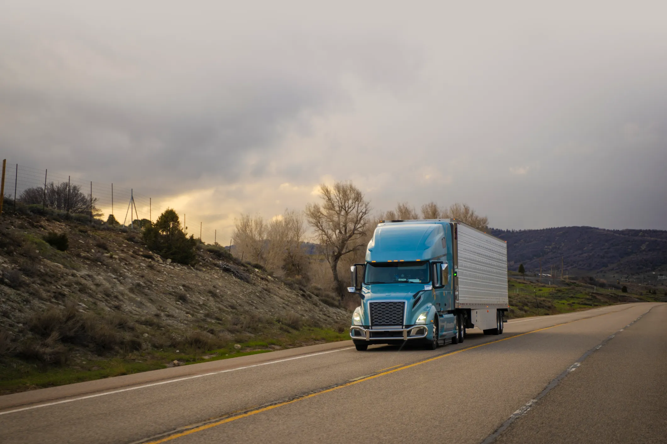 View from inside a truck showing the driver at the wheel.