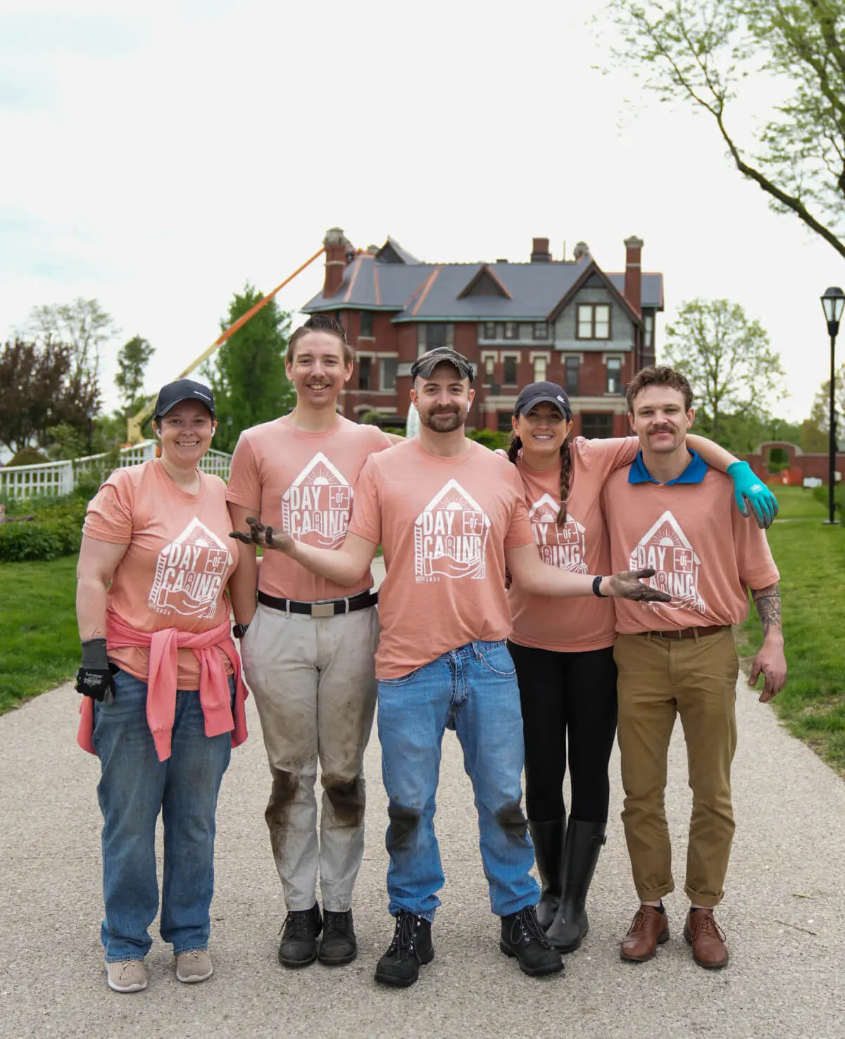 Group photo of people wearing matching shirts outdoors.