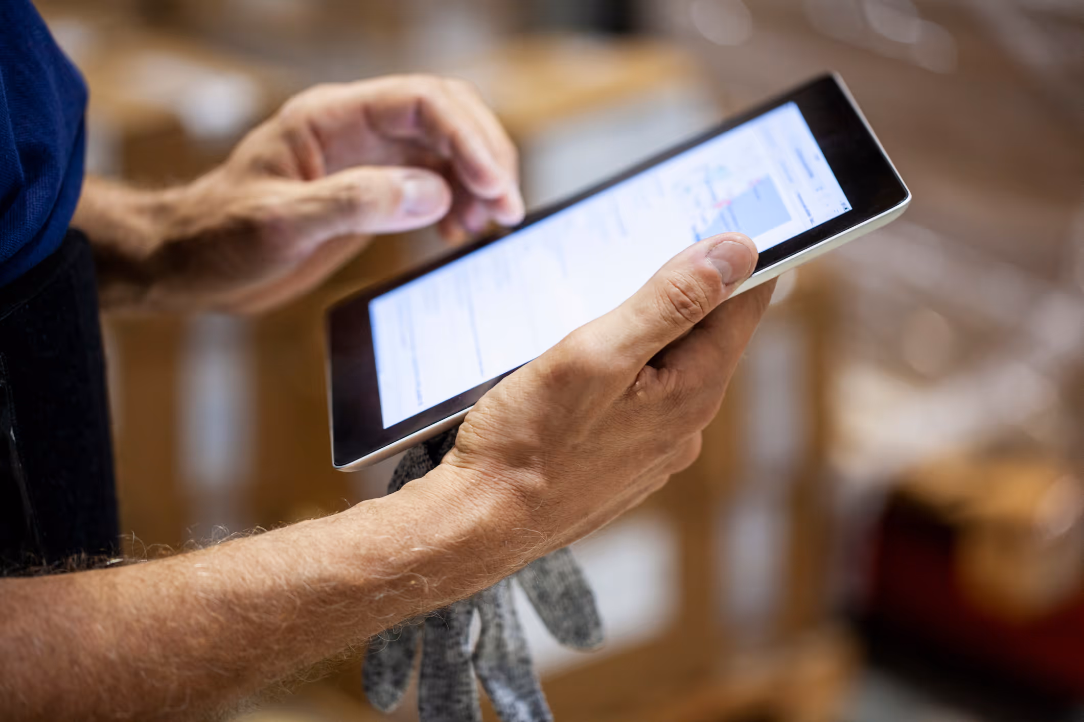ipad in hands also holding a work glove