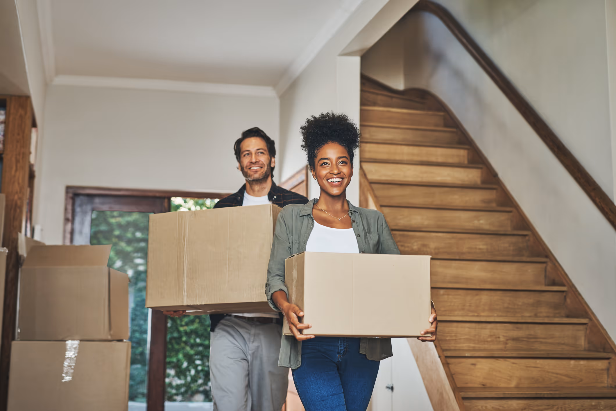 couple carrying boxes out of a home