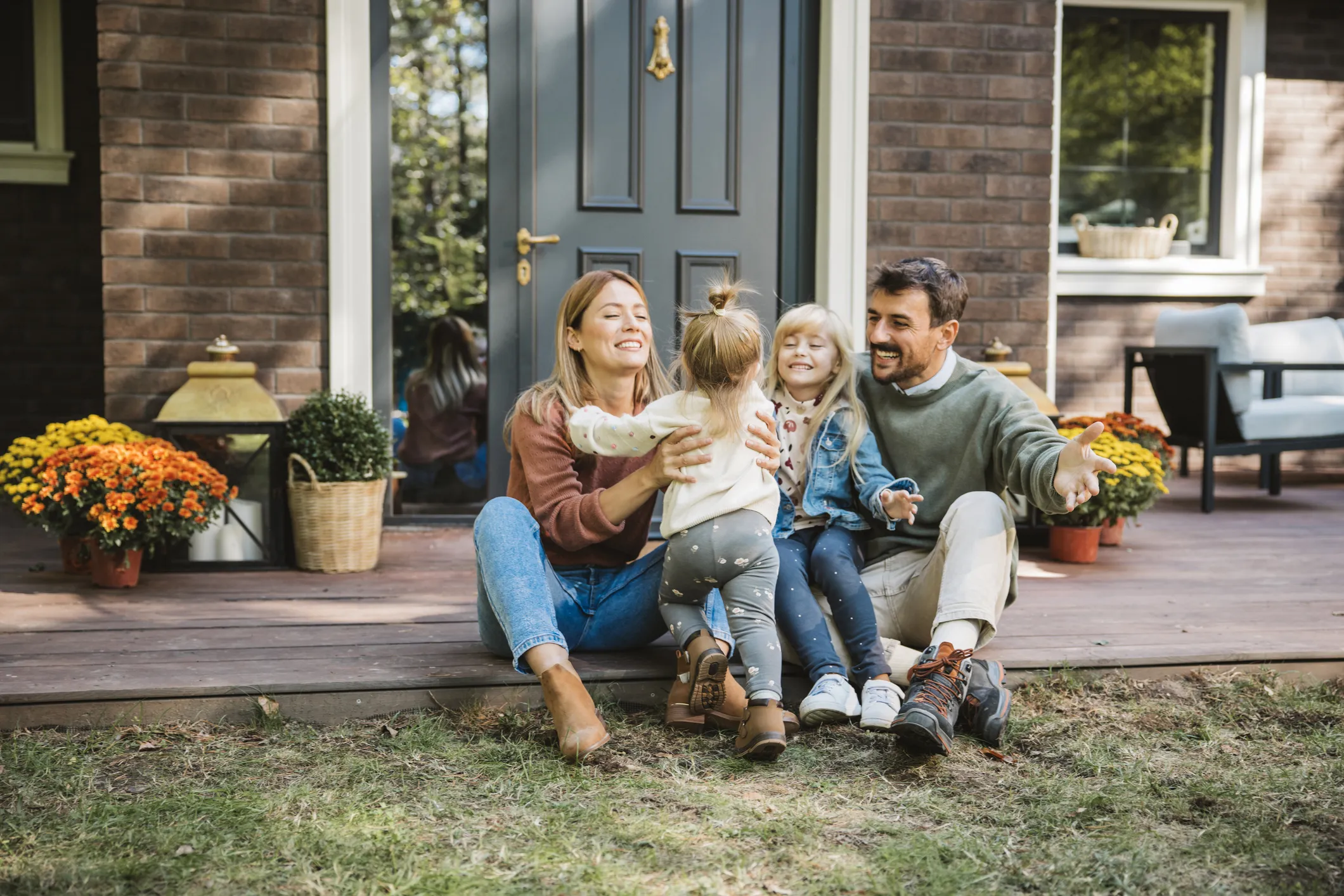 family sitting on porch hugging