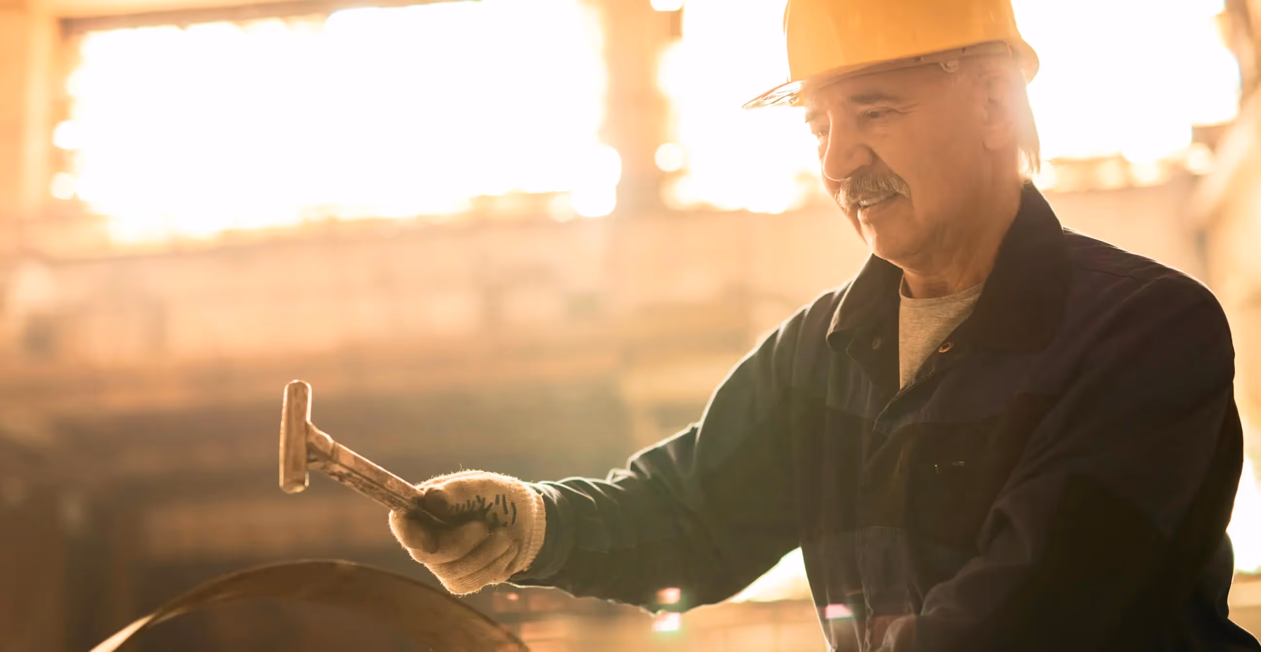 Photo of a factory worker holding a hammer