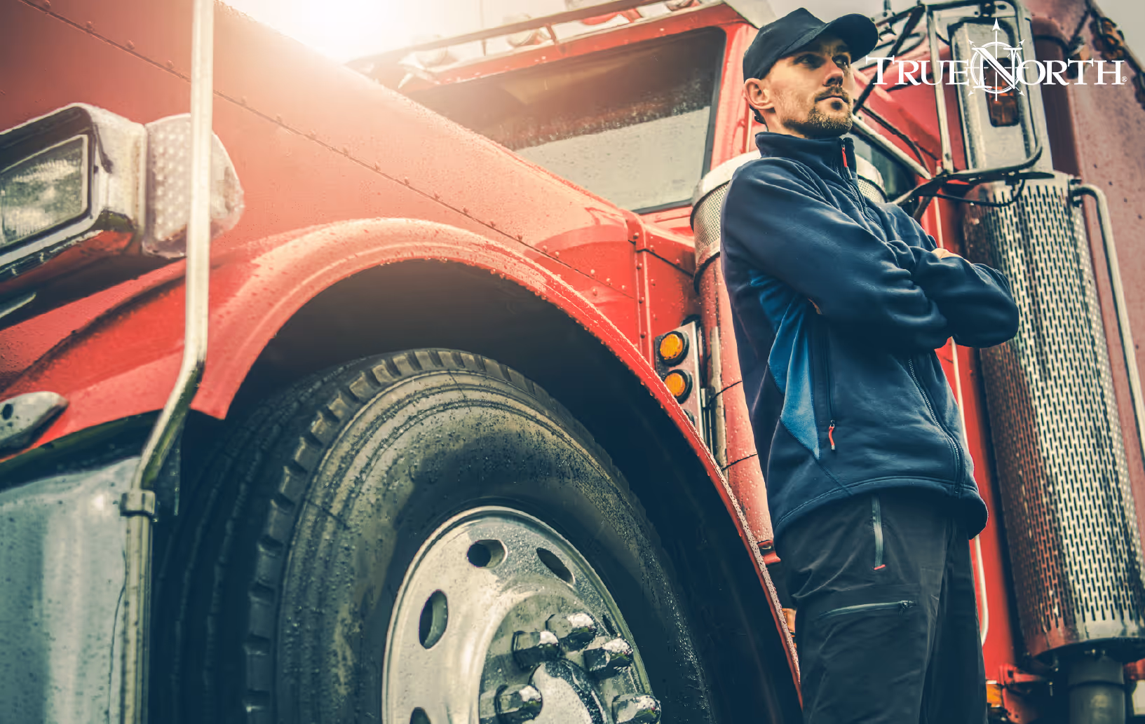 man leaning against semi-truck with arms crossed