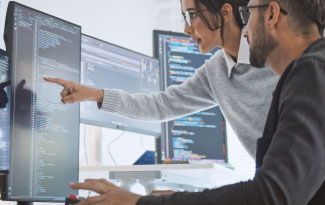 A woman and man collaborate on computer work.