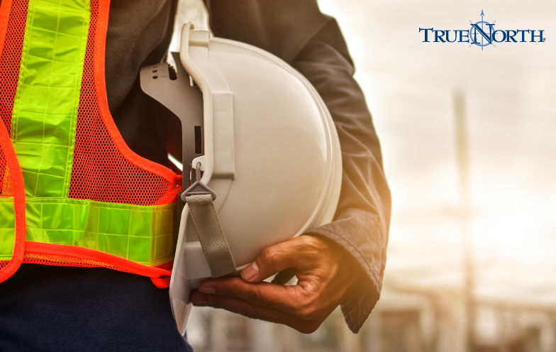 A construction worker holding a hard hat