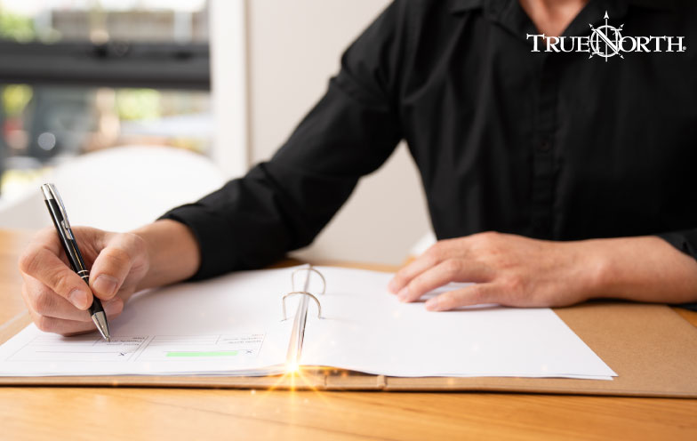 Person writes notes in open notebook.