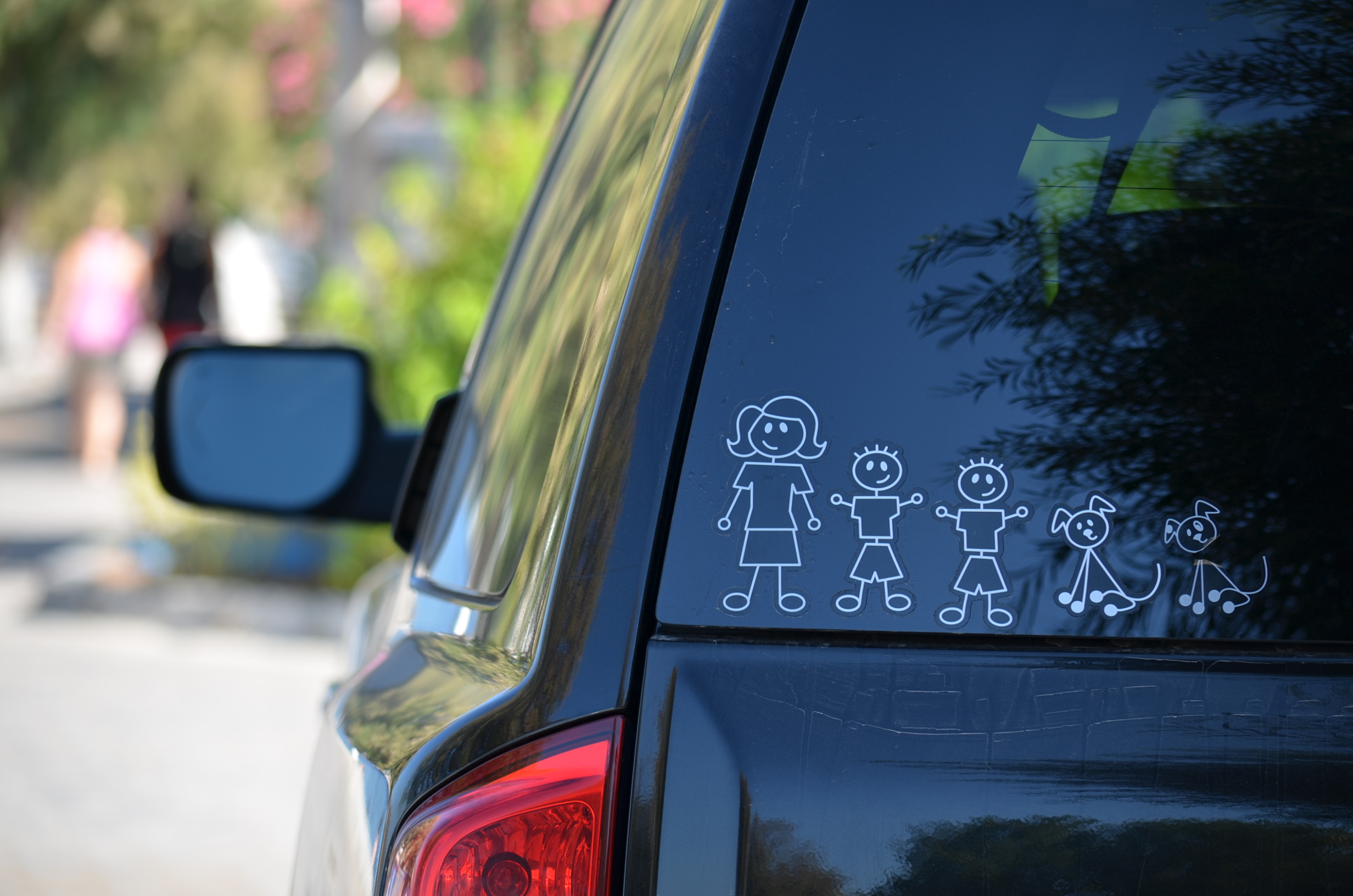A car with a family decal on the rear windshield.