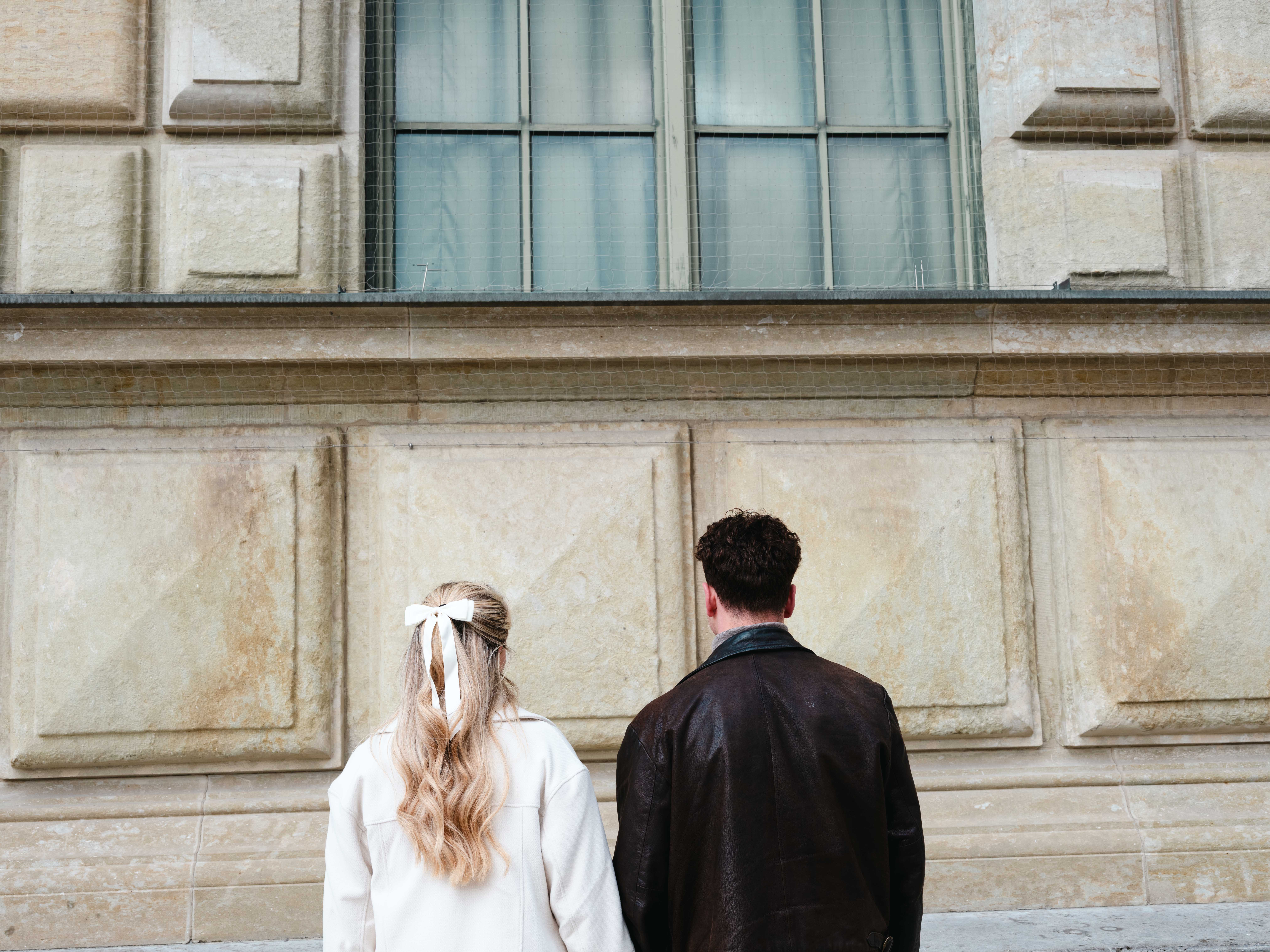 a man and woman standing in front of a building