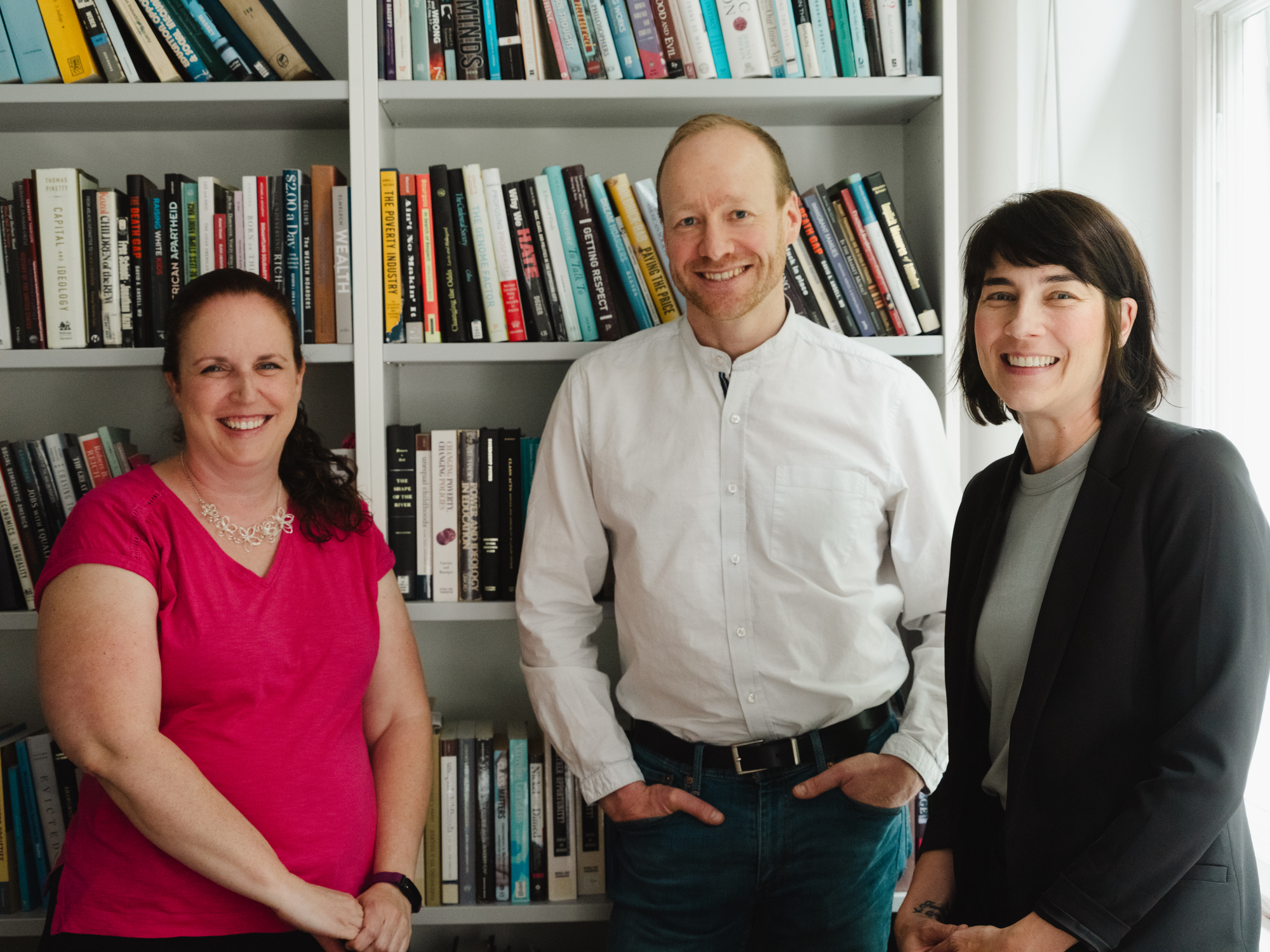 a group of people standing in front of a bookcase