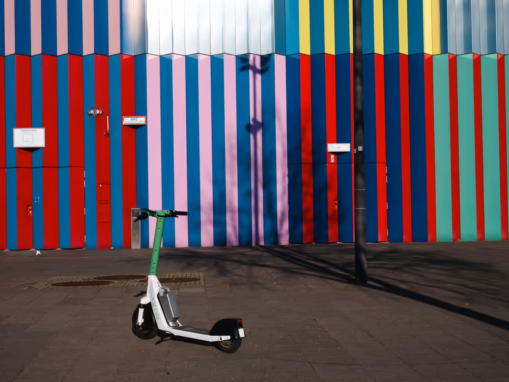 a scooter in front of a colorful wall