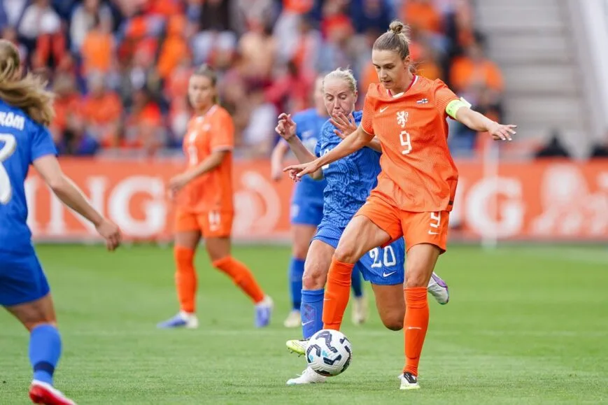 Dutch women's national football team players in orange jerseys during match action