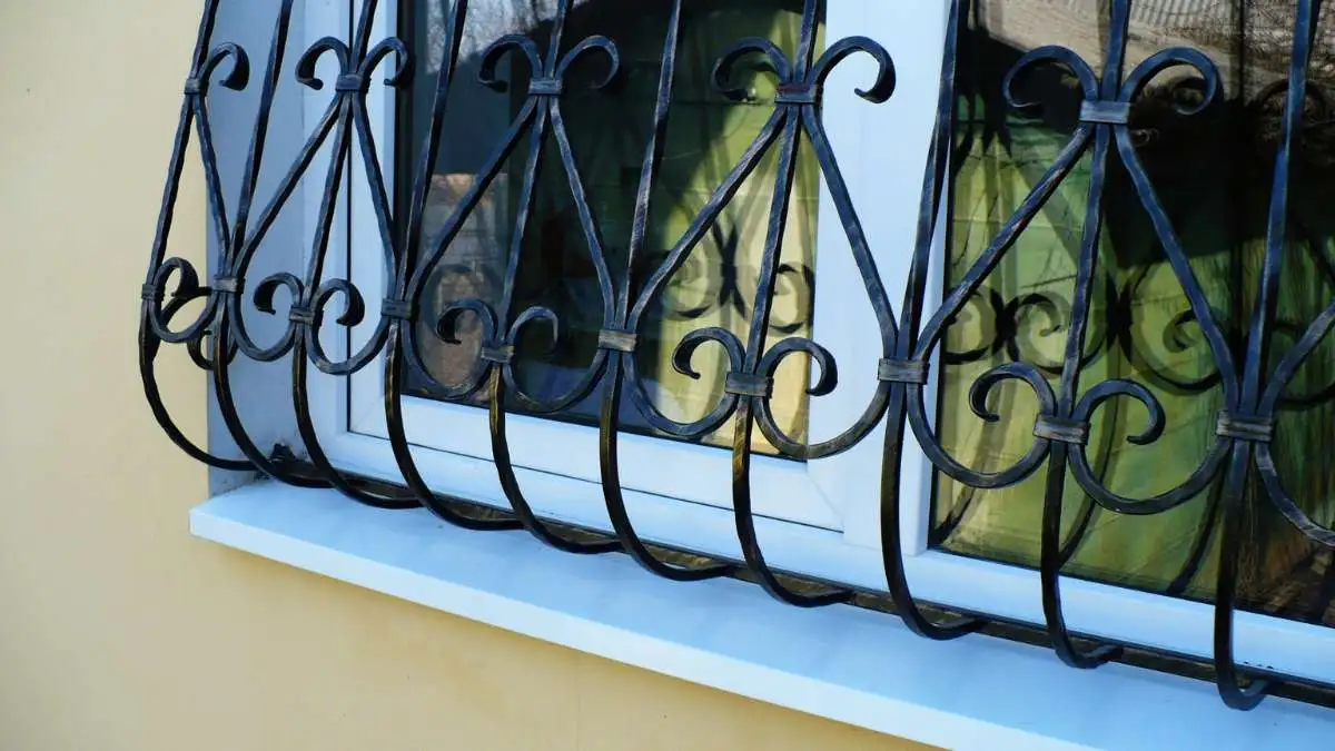 Historic window with curved metal bars and flower boxes
