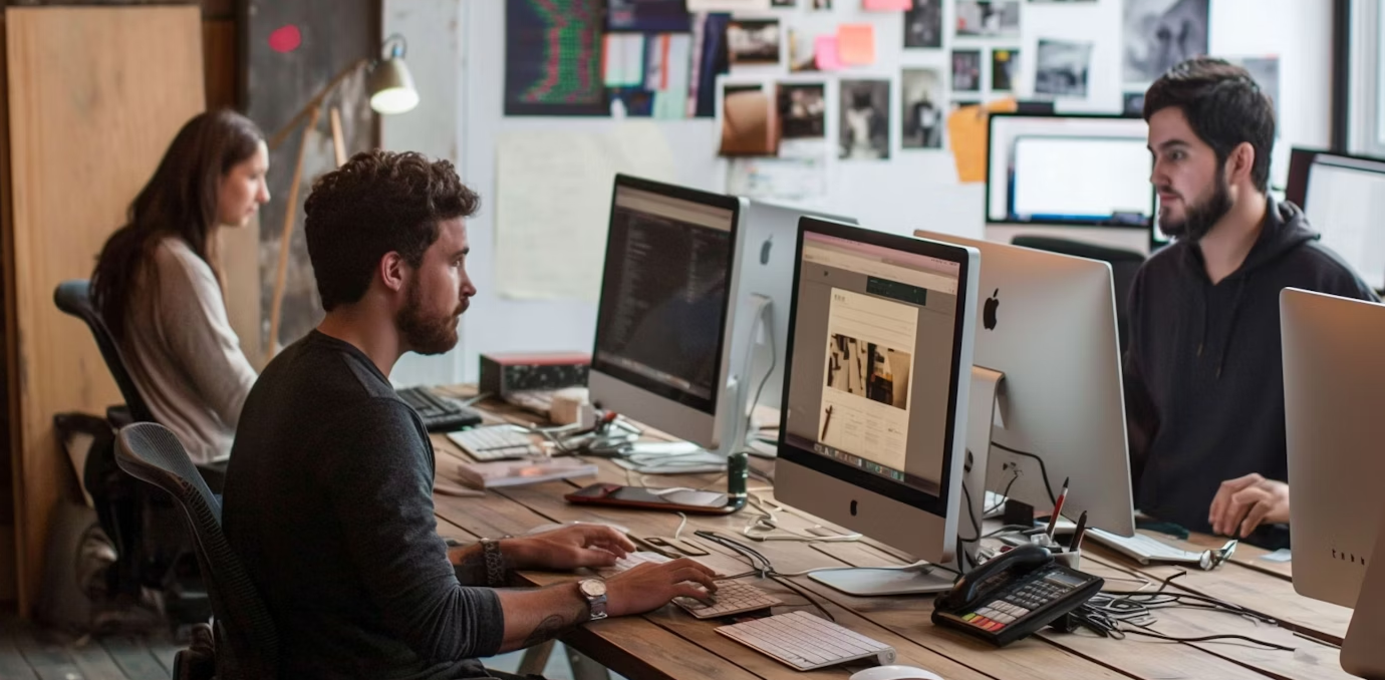 A diverse group of professionals collaborating on computers in a modern office environment.