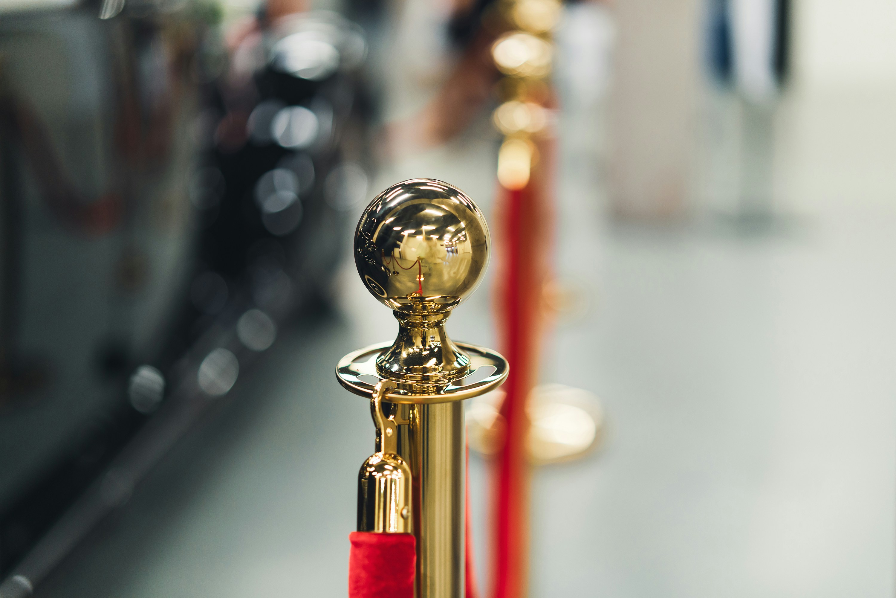 Close-up of a golden stanchion with a red velvet rope at the Oscars 2025 red carpet — symbolizing exclusive access to the star-studded event.