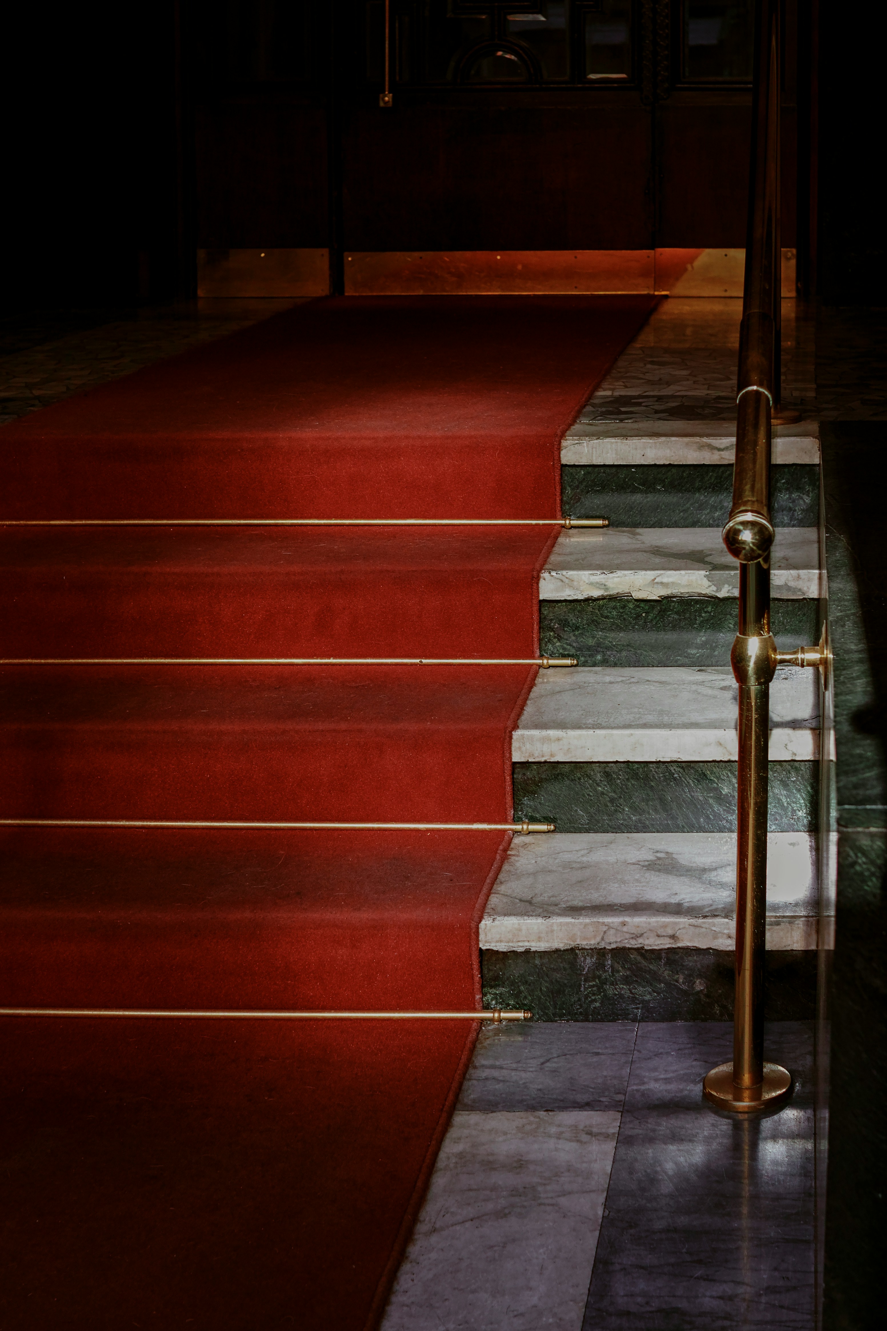 Red carpeted stairs with brass railings at the entrance to the Met Gala 2025.