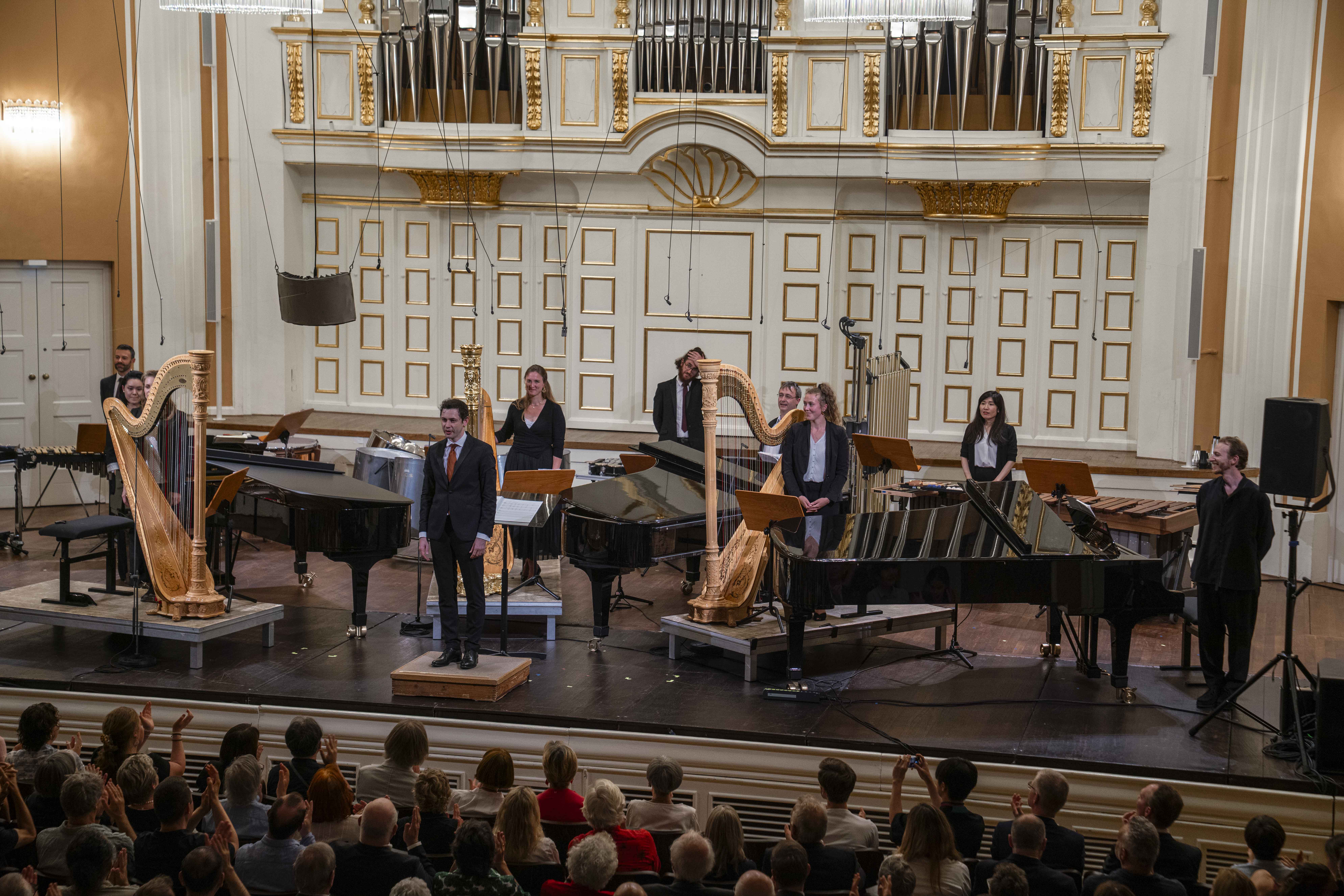 Contemporary classical music ensemble performing with harps and grand pianos at Mozarteum Salzburg.
