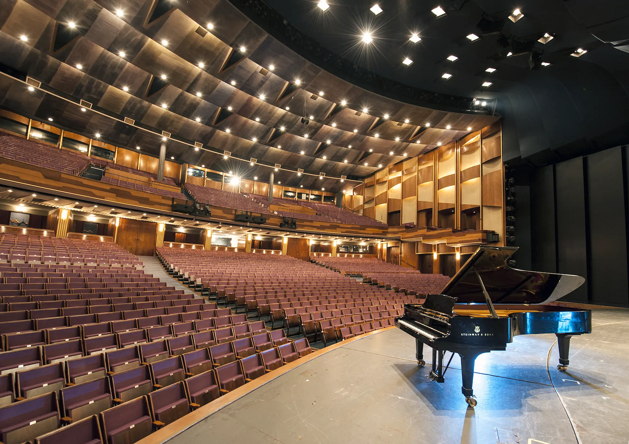 View from the stage into the empty auditorium of the Großes Festspielhaus, with a grand piano in the foreground.