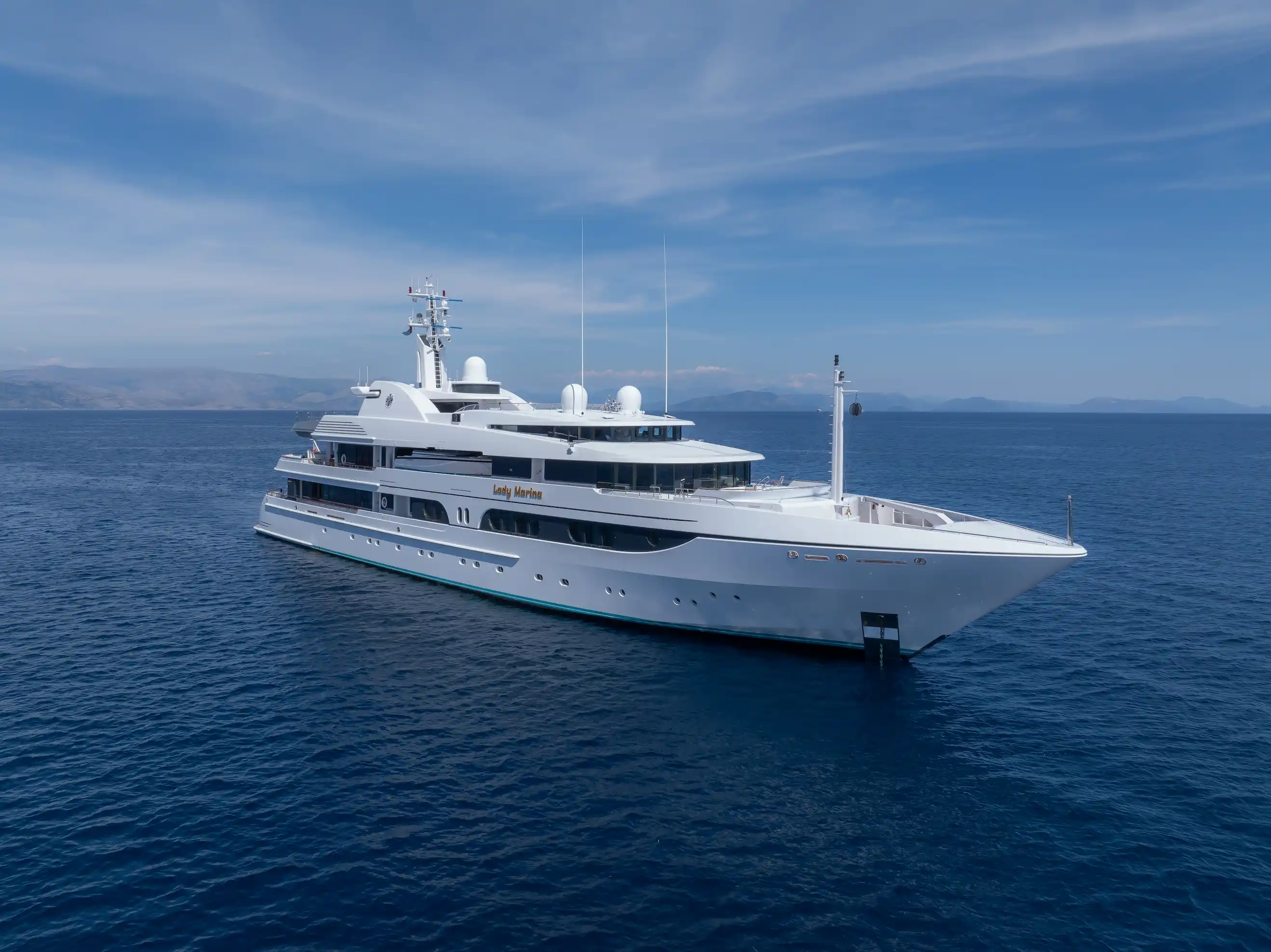 The elegant Feadship superyacht LADY MARINA sailing in open waters, presented during the 2025 Monaco Yacht Show against a serene ocean backdrop.