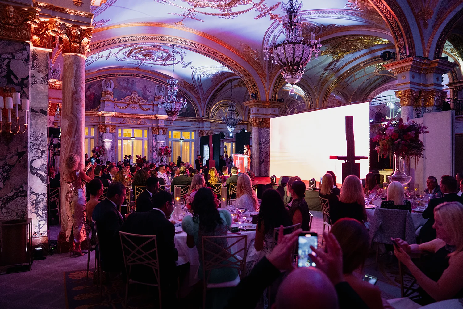Guests seated in the opulent Salle Empire at Hôtel de Paris Monte-Carlo during the Global Gift Gala Monaco 2025, with a speaker on stage under ornate chandeliers and golden arches.