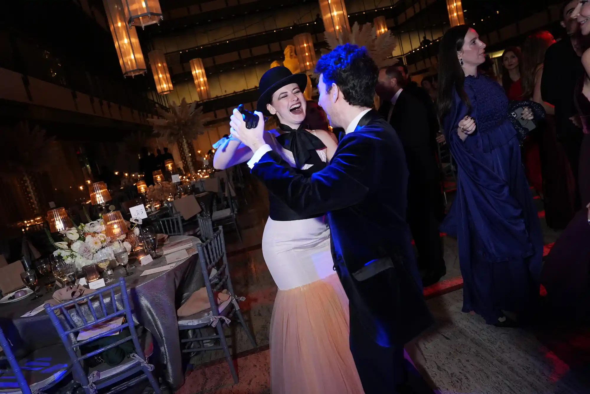 A joyful couple dancing at the New York City Ballet Fall Fashion Gala 2025 surrounded by candlelit tables.
