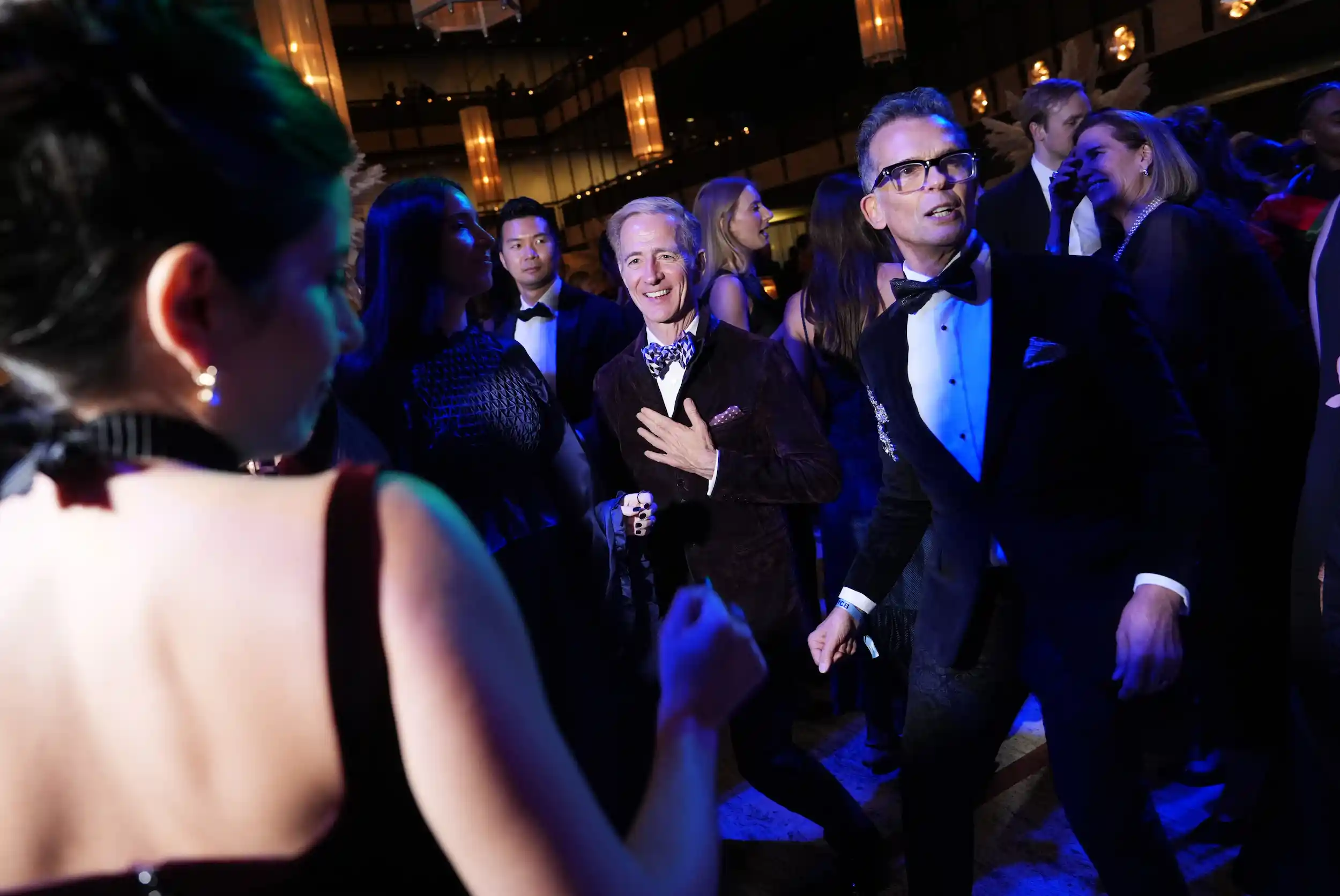 Guests dancing under blue lights at the 2025 New York City Ballet Fall Fashion Gala.