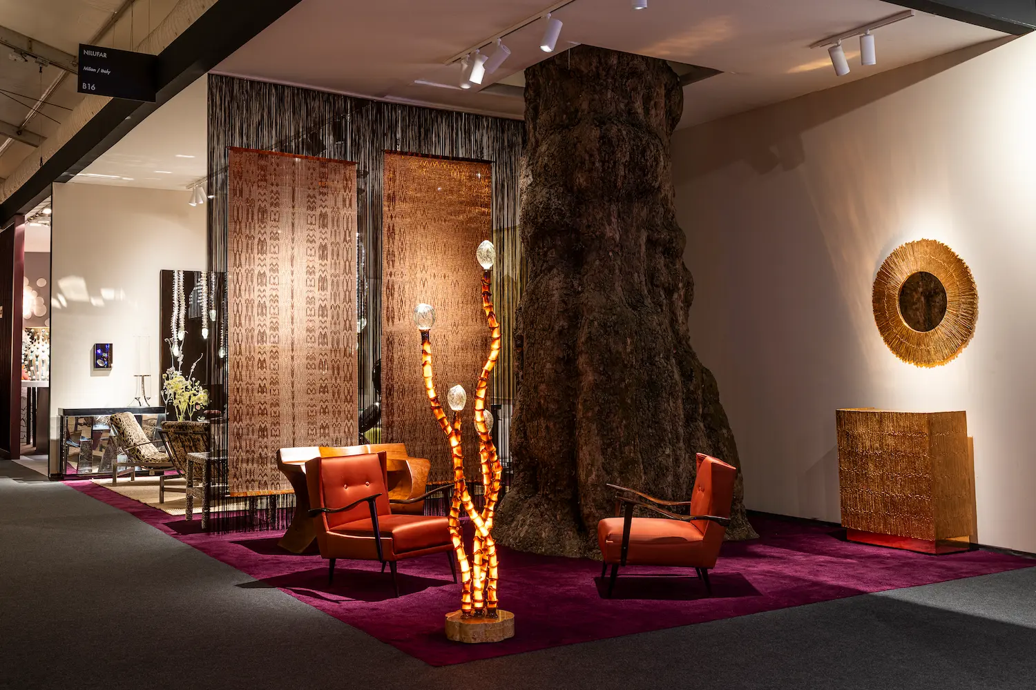 Nilufar Gallery’s booth at PAD London 2025 featuring warm-toned modern furniture, artistic lighting, and textured wall pieces, showcasing Italian craftsmanship and a fusion of mid-century design with contemporary artistry.