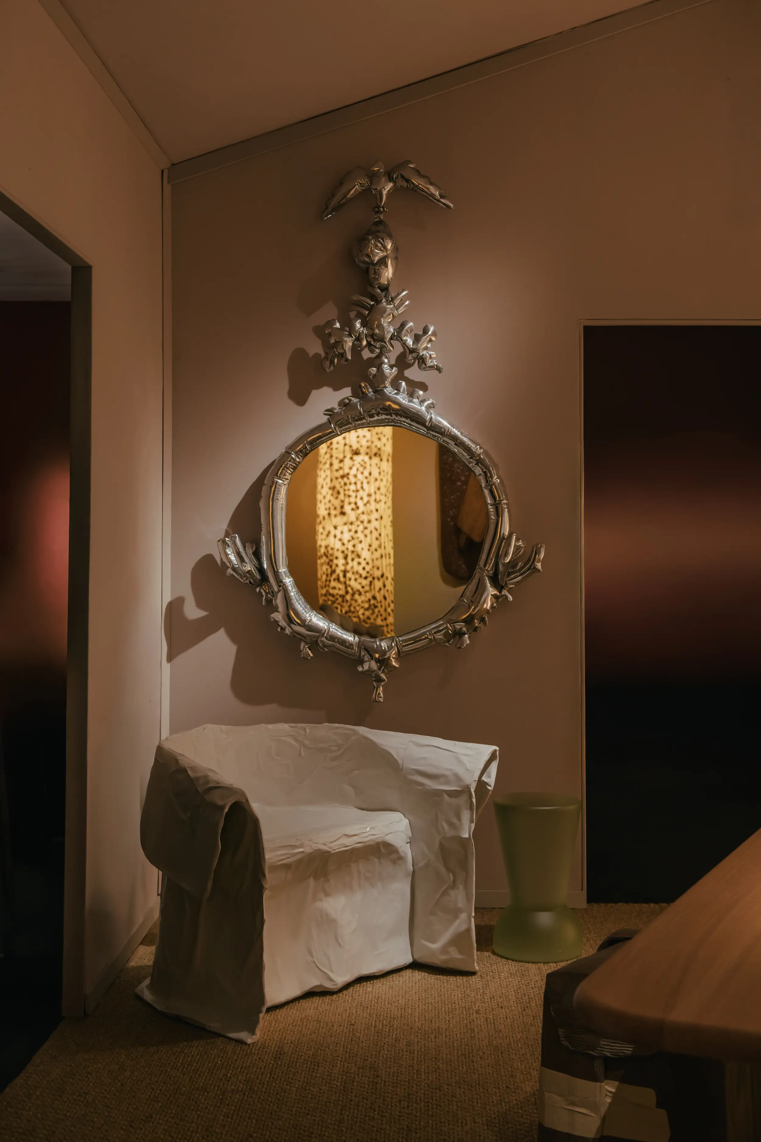 Close-up view of Faye Toogood’s “Paper Chair” installation at Friedman Benda’s booth during PAD London 2025, featuring the sculptural white armchair beneath an ornate metallic mirror in a softly lit, minimalist setting.