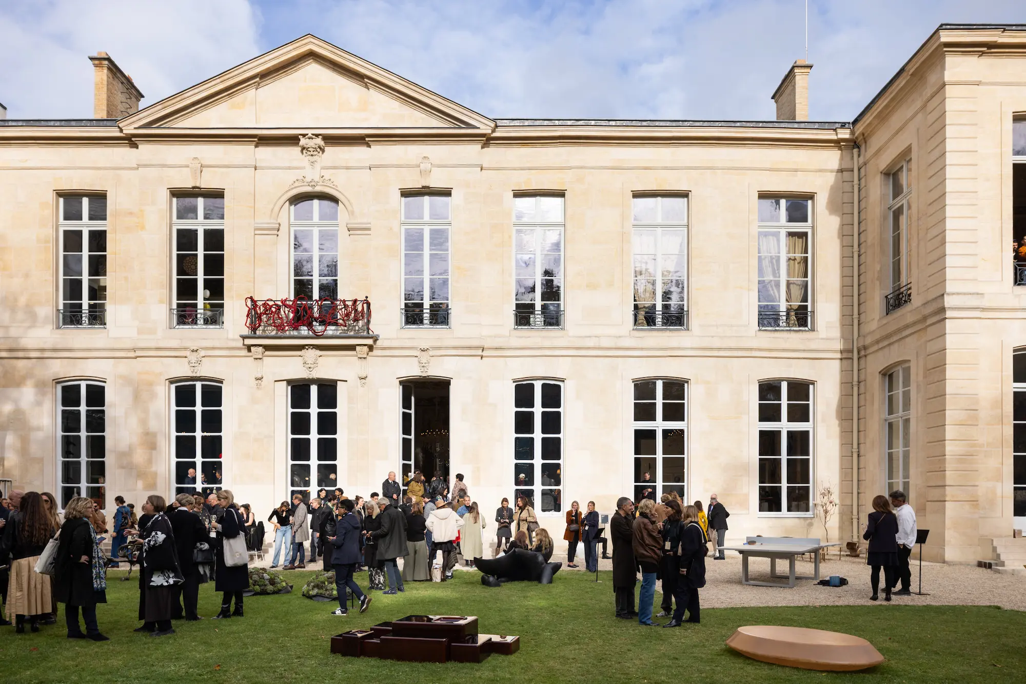 Guests gather in the garden of the Hôtel de Maisons during Design Miami.Paris 2025, surrounded by contemporary outdoor sculptures and installations set against the elegant 18th-century Parisian façade.