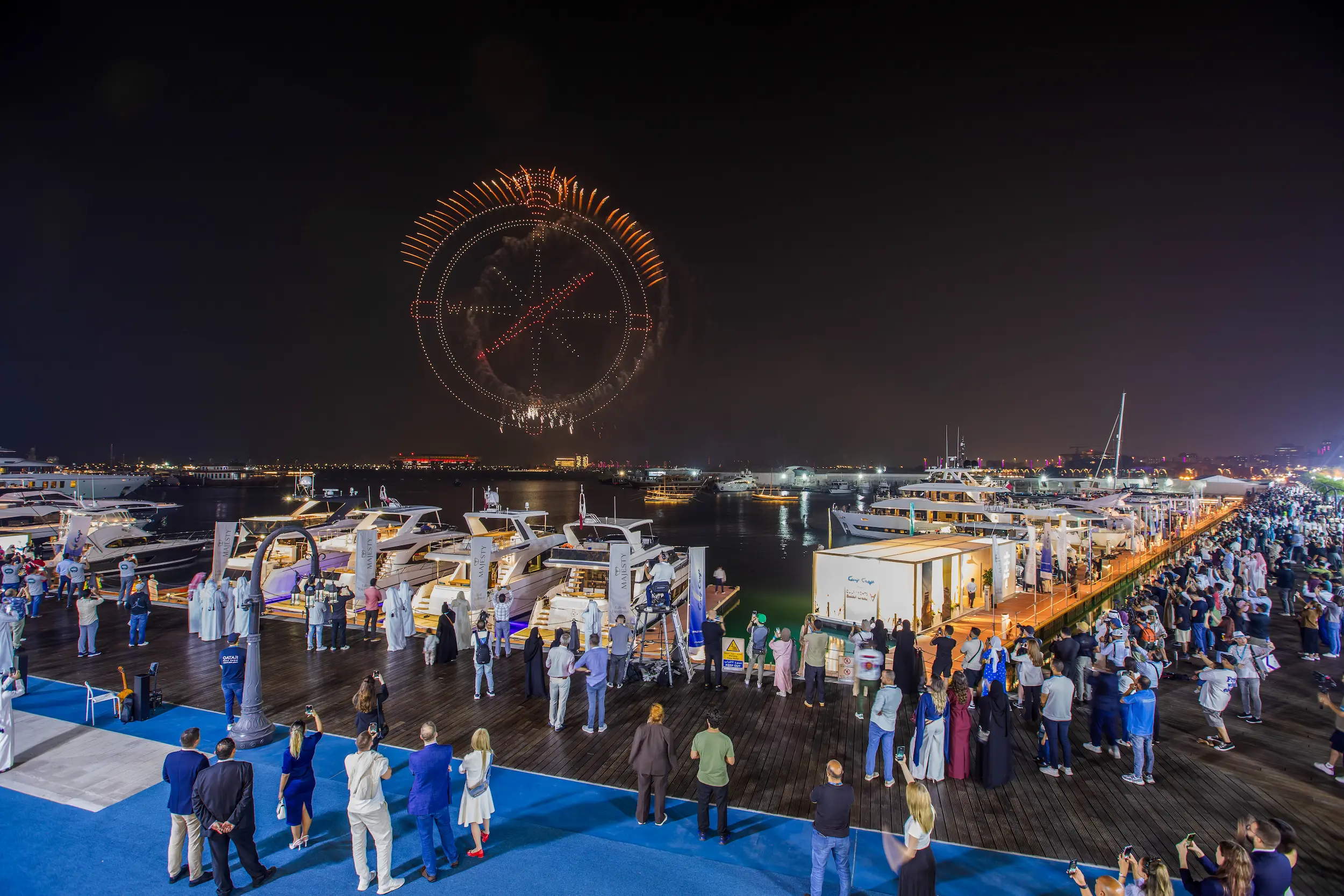 Visitors gather along the marina at Old Doha Port to watch a stunning drone and fireworks display above luxury yachts during the Qatar Boat Show 2025 opening night.