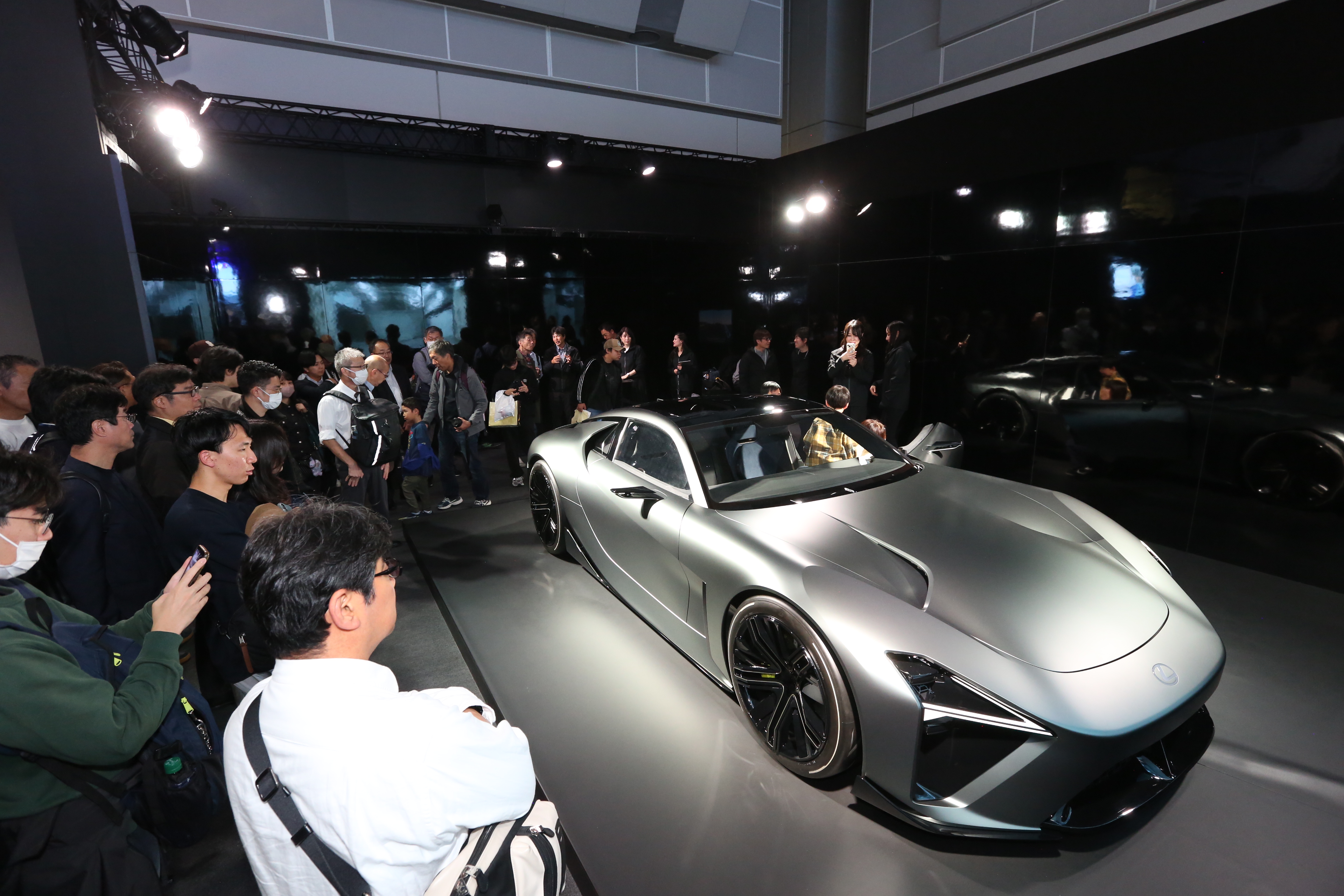 Visitors gather around the sleek Lexus Electrified Sports Concept at the Japan Mobility Show 2025 in Tokyo, admiring the futuristic design and cutting-edge technology of the luxury electric supercar.