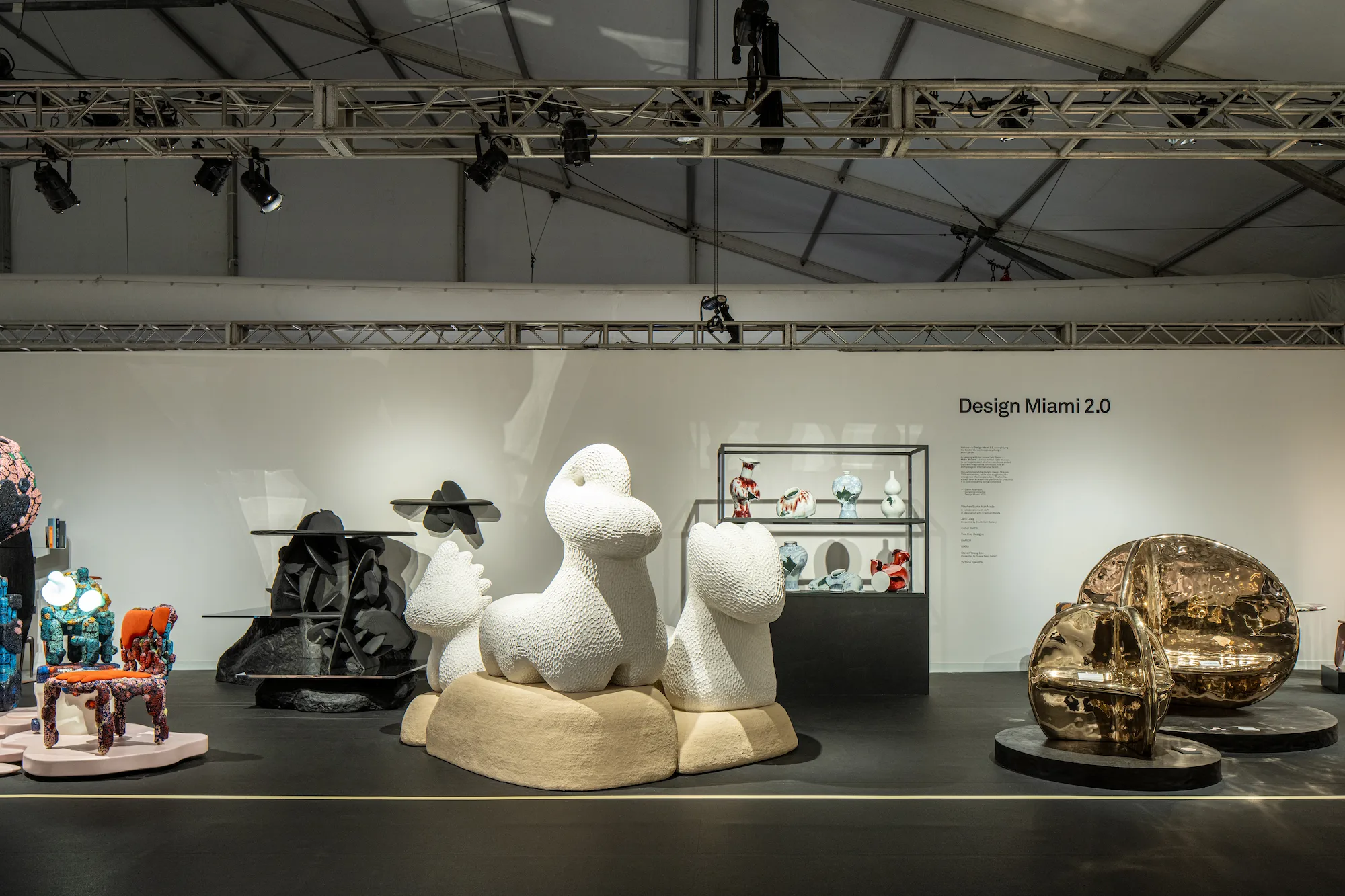 Victoria Yakusha installation at Design Miami 2.0 featuring large-scale organic white textured sculpture on sand-colored base in exhibition space with black angular furniture and bronze pieces