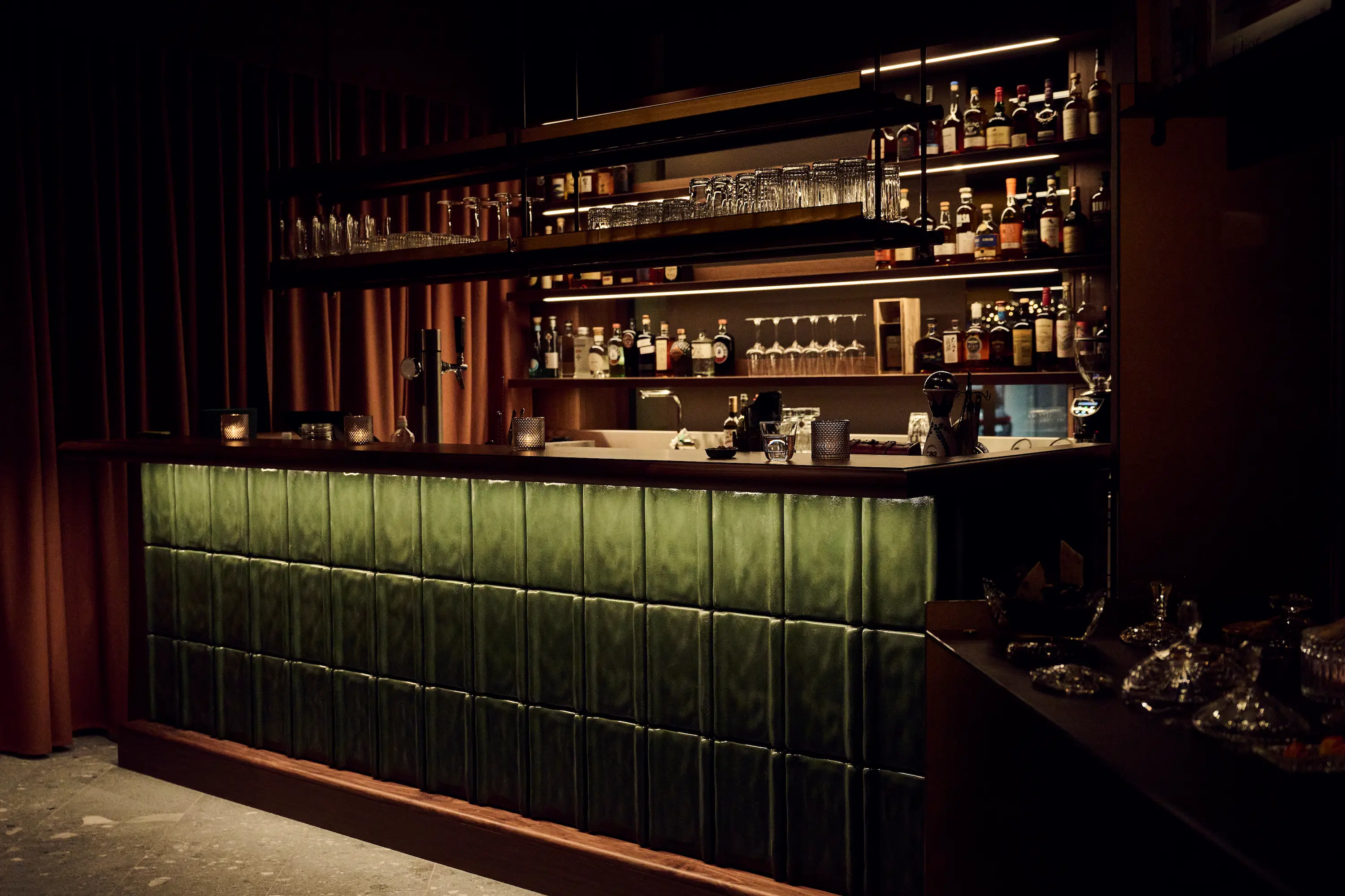 Two elegant cocktail glasses with olives beside a tennis ball on a sunlit table, evoking a luxurious summer tennis lifestyle.