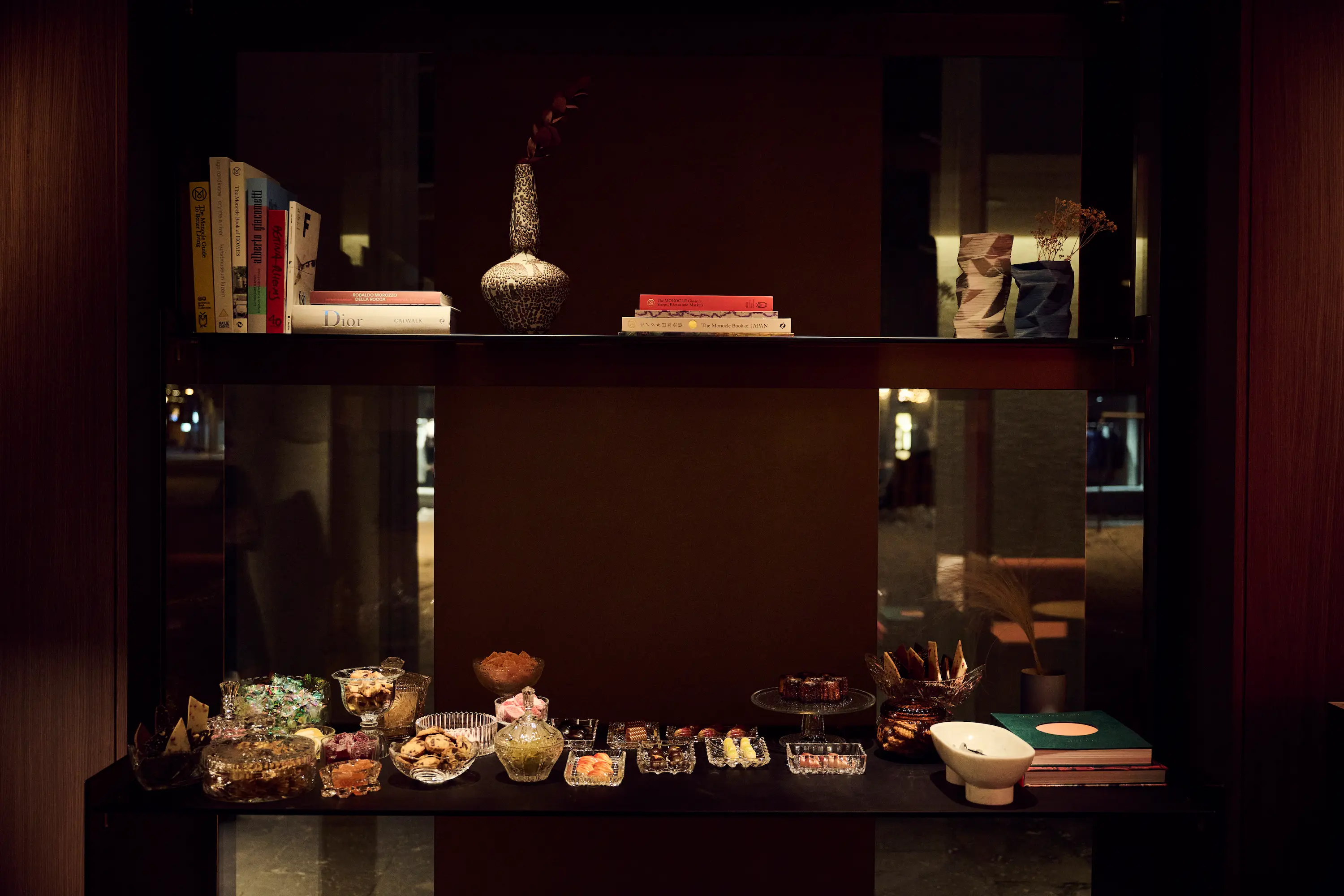 Elegant shared tasting dishes featuring duck preparation with Jerusalem artichoke and seasonal vegetables on burgundy velvet table at IGNIV Andermatt by Chef Valentin Sträuli