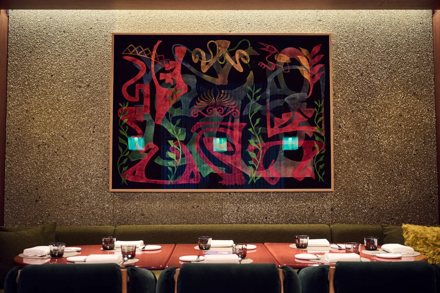 Whimsical colorful painting by American artist Philip Taaffe displayed above burgundy velvet banquette with set dining table at IGNIV Andermatt's curated contemporary art collection