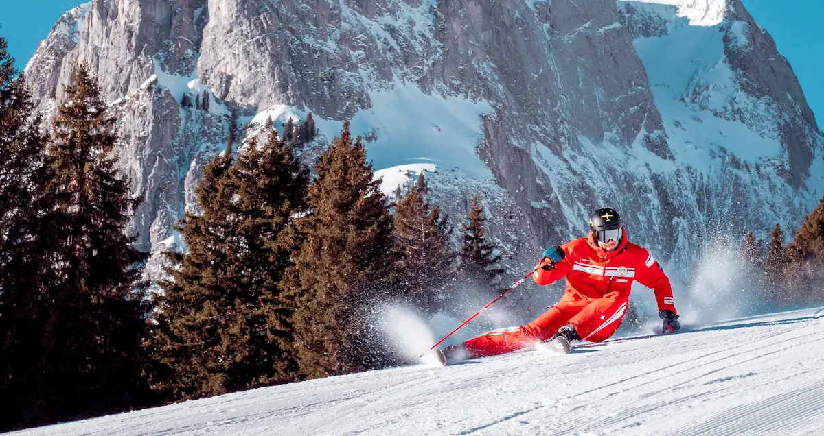 Cross-country skiing lesson at Ski School Rougemont with instructor and guest gliding through postcard woodlands in Pays d'Enhaut valley with dramatic Alpine peaks backdrop