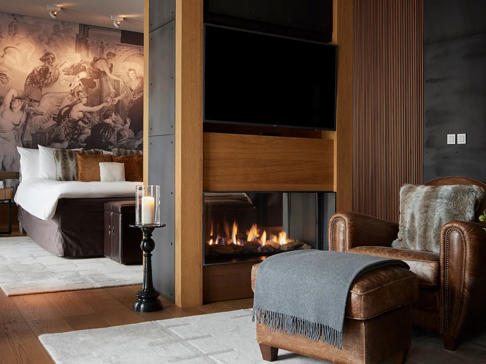 Luxurious Junior Deluxe Suite bathroom at The Chedi Andermatt featuring warm timber paneling, three decorative illuminated mirrors with cross-pattern frames, double vessel sinks, freestanding bathtub, glass-enclosed shower, and natural stone flooring