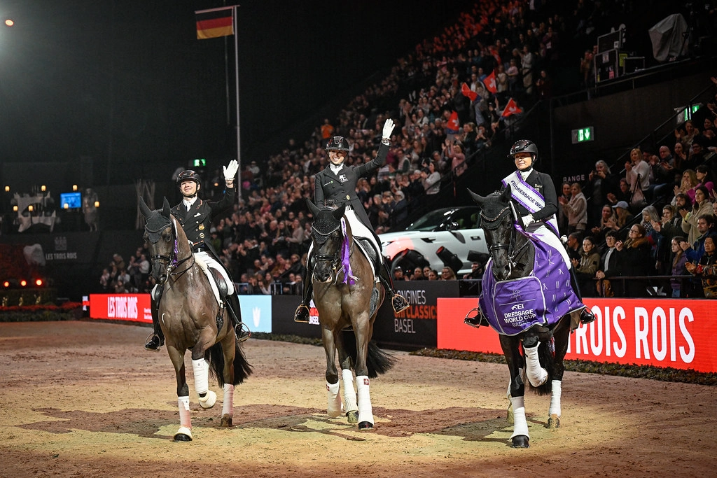 FEI Dressage World Cup Basel podium ceremony with three equestrian riders in formal dressage attire