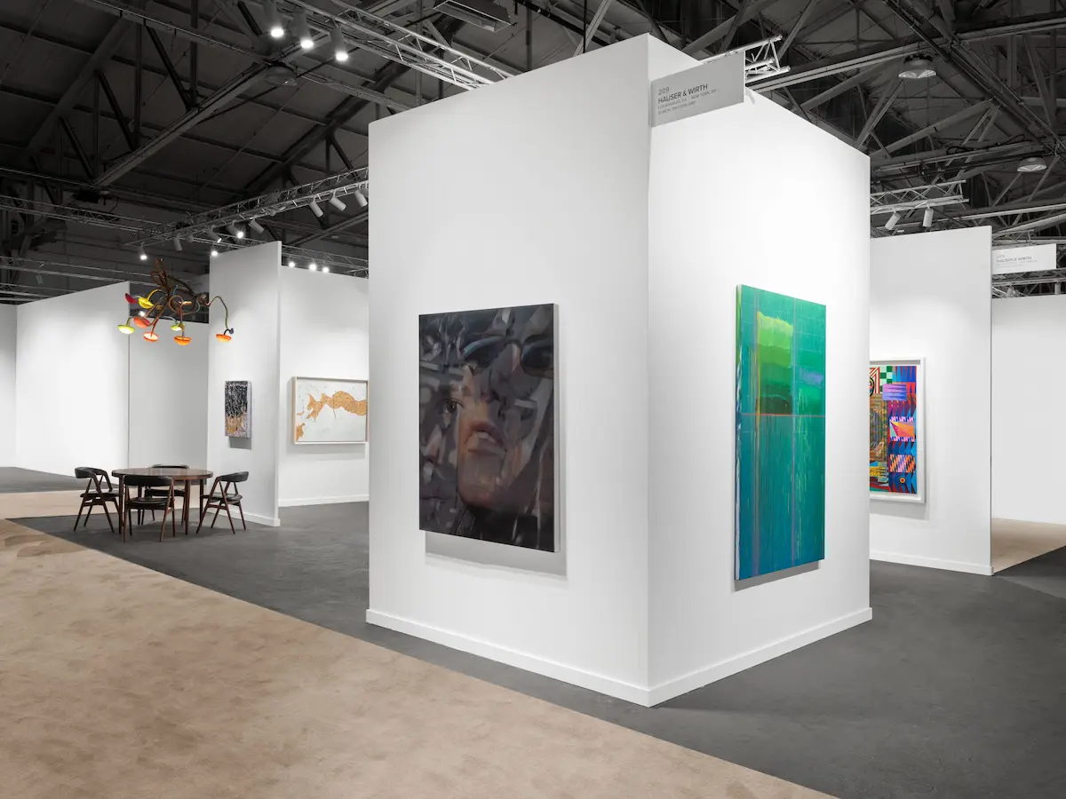 Pristine white cube gallery booth by Hauser & Wirth at FOG Design+Art 2026 Fort Mason showing tall white partition walls displaying contemporary artworks including large monochromatic portrait